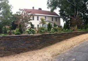 The trees and shrubs of the newly planted border revealing framed views of the house